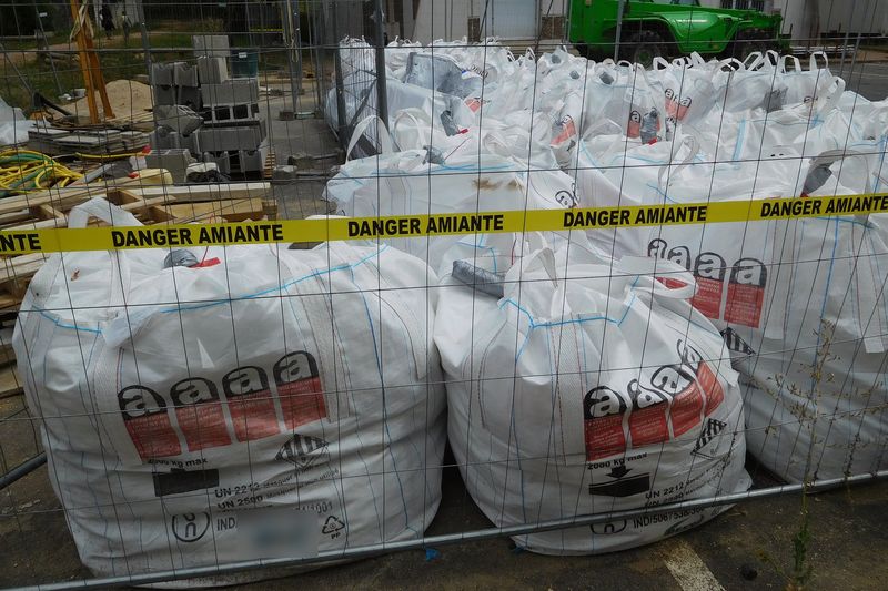 Big bags com resíduos de amianto embalados e sinalizados numa obra, prontos para transporte